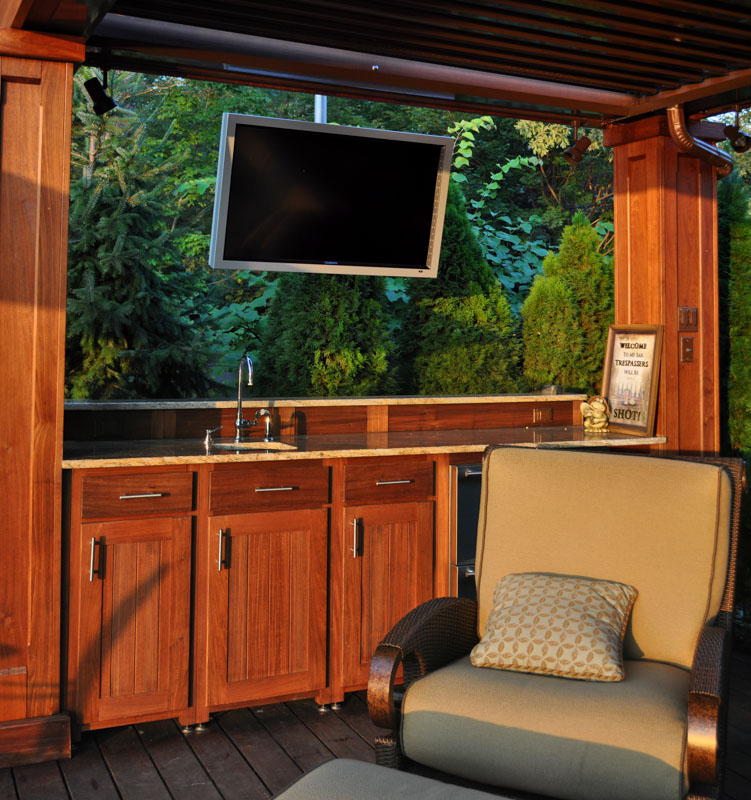 wet bar and television in outdoor living area