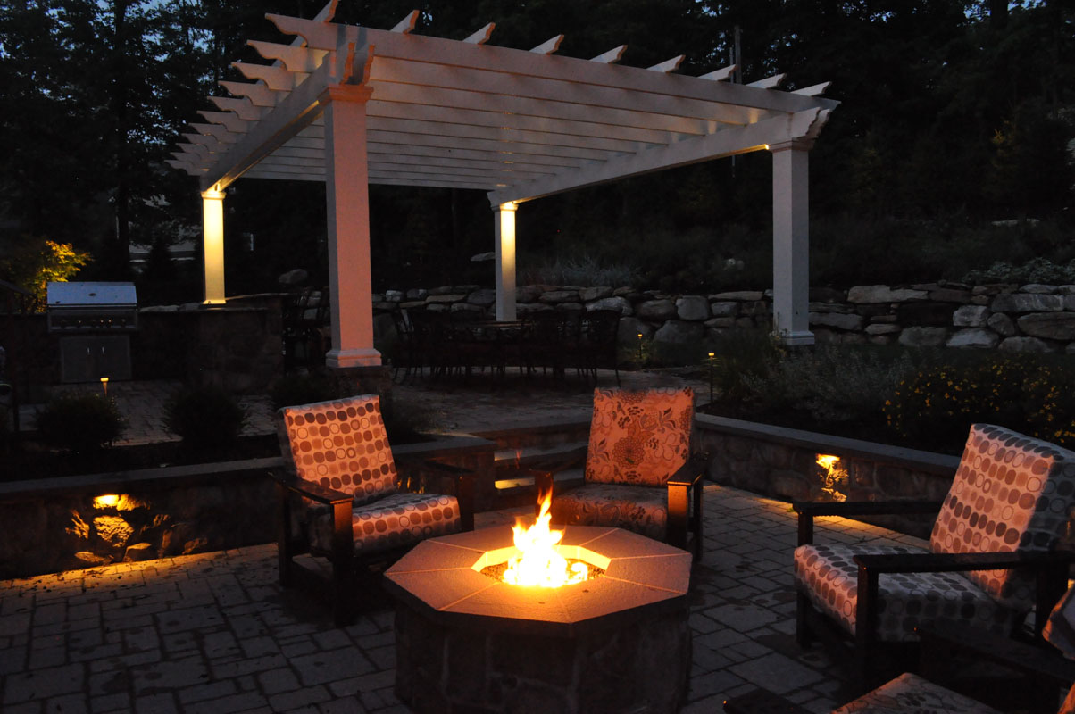 gas fire pit at night with fire in it, landscape lighting - north jersey