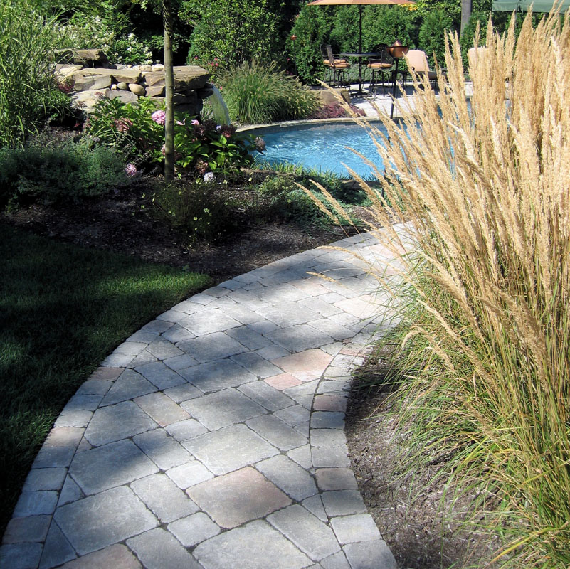 Landscaped Paver Walkway Leading to Backyard Landscape with Pool