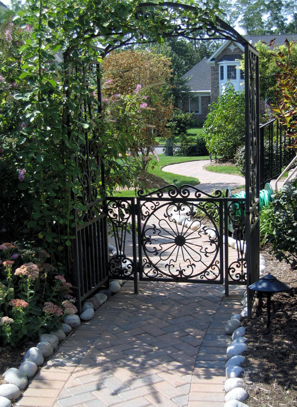 Paver Walkway Leading Through Arch and Gate