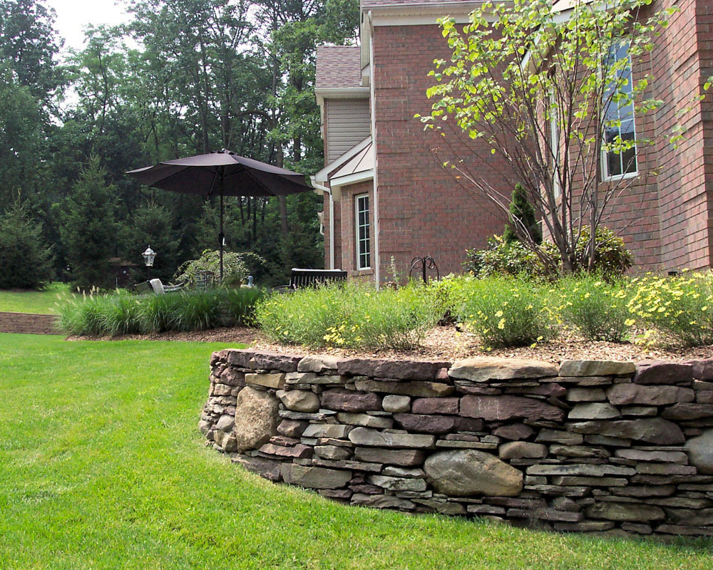 pennsylvania fieldstone retaining wall creates plant bed