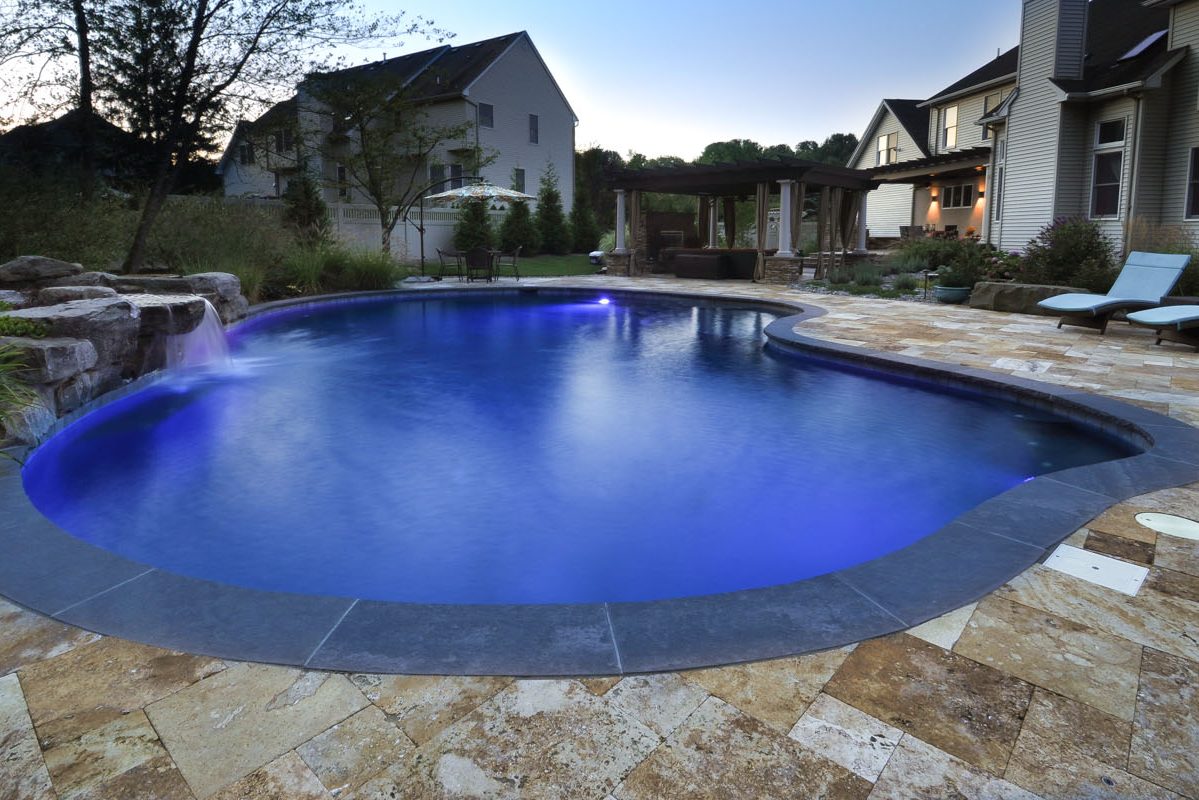 custom gunite swimming pool with travertine and brownstone pool patio