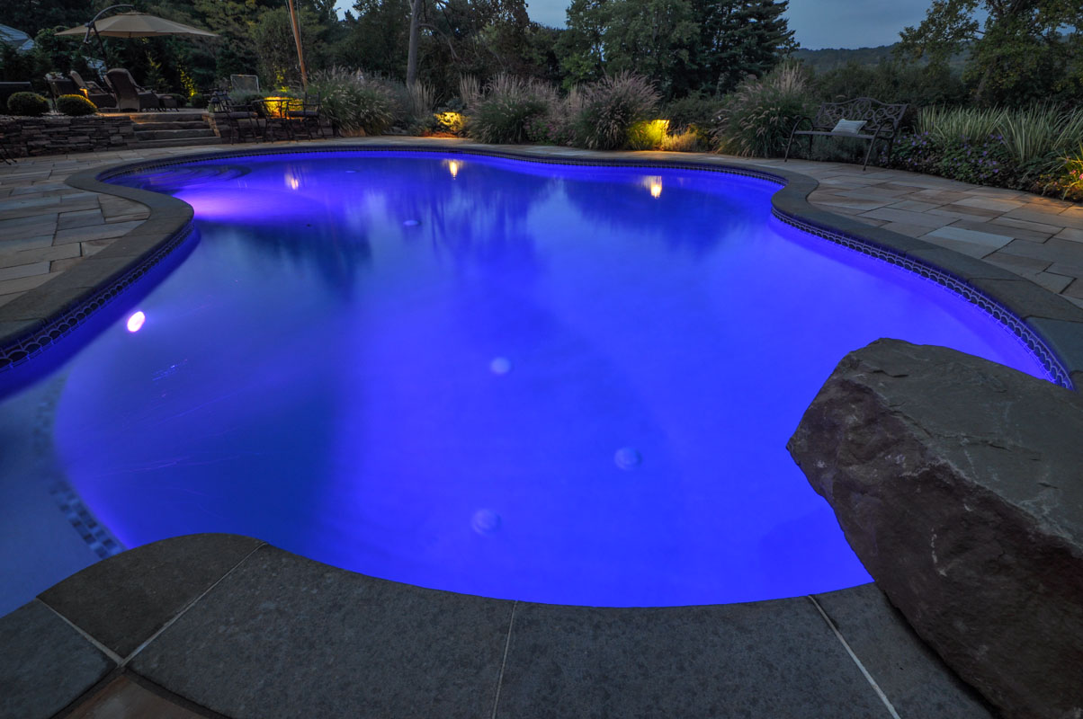 custom swimming pool design, pool at night with lighting