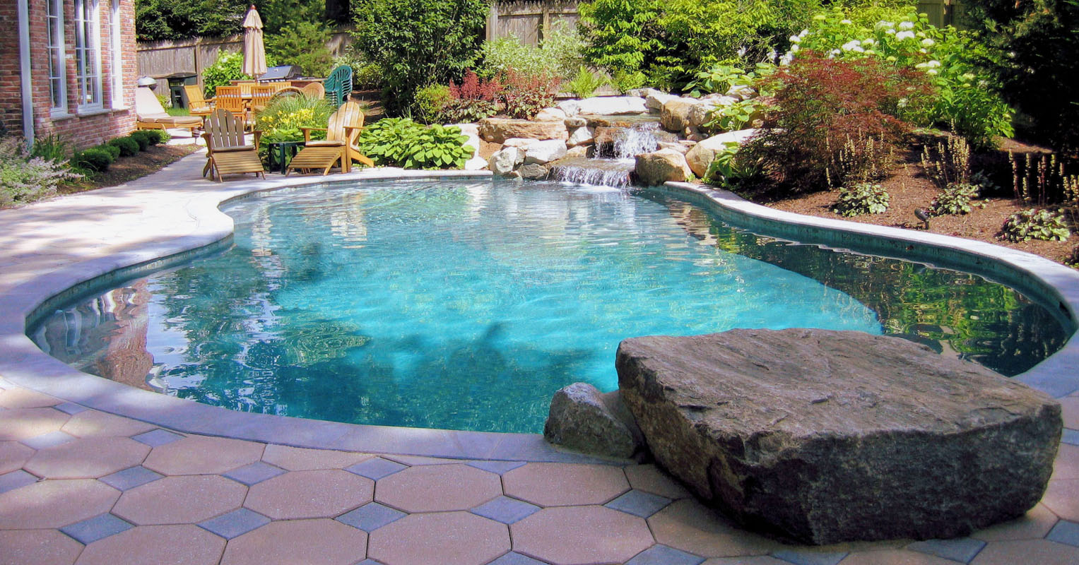gunite swimming pool with dive rock and natural stone waterfall