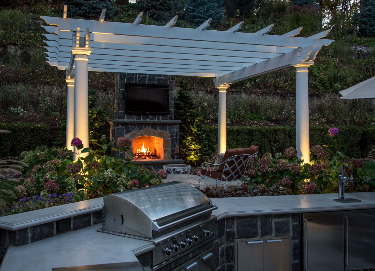 outdoor kitchen with granite countertop, pergola with outdoor fireplace