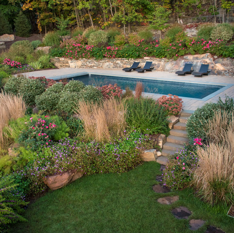 pool area with stone slab steps leading to lower grass area