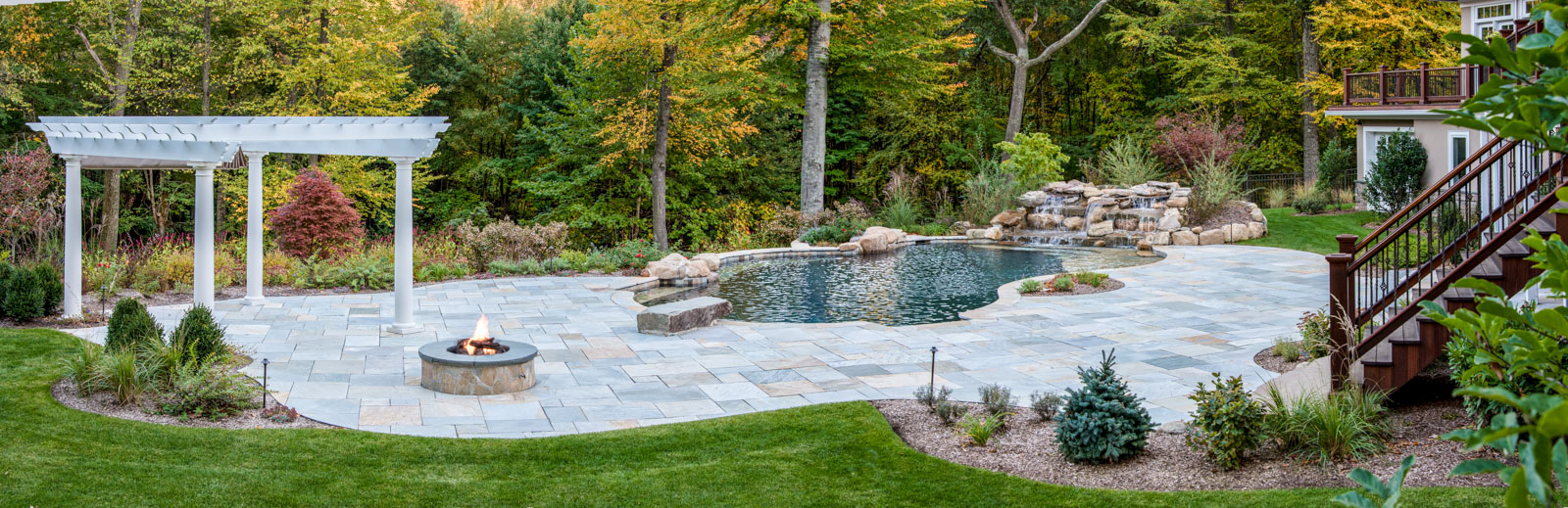 mountain lakes landscape design with custom pool, pergola, fire pit, and pool waterfall