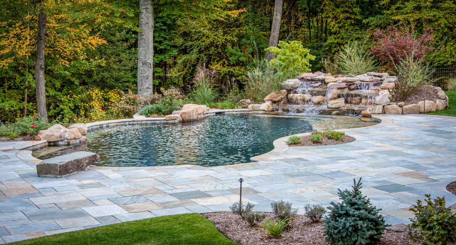 custom swimming pool with waterfall and dive rock