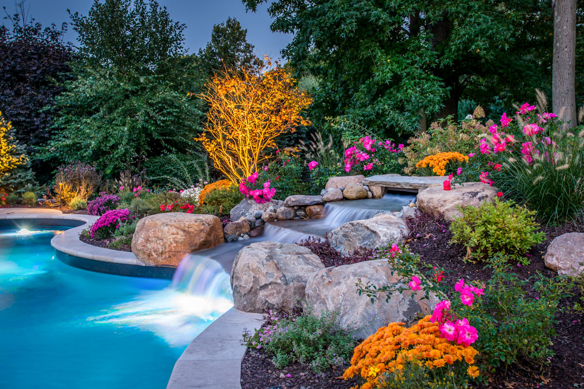 pool waterfall with plantings and landscape lighting