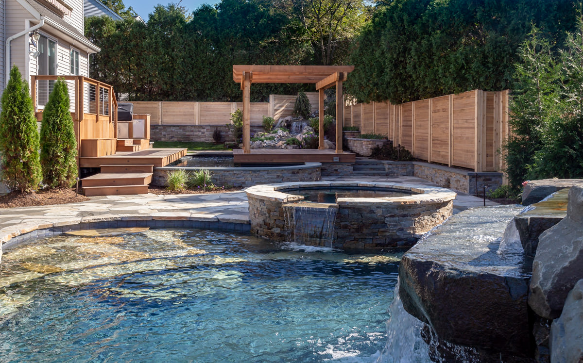 rockland county backyard landscape, custom swimming pool with waterfall, spa, pergola, and ipe deck