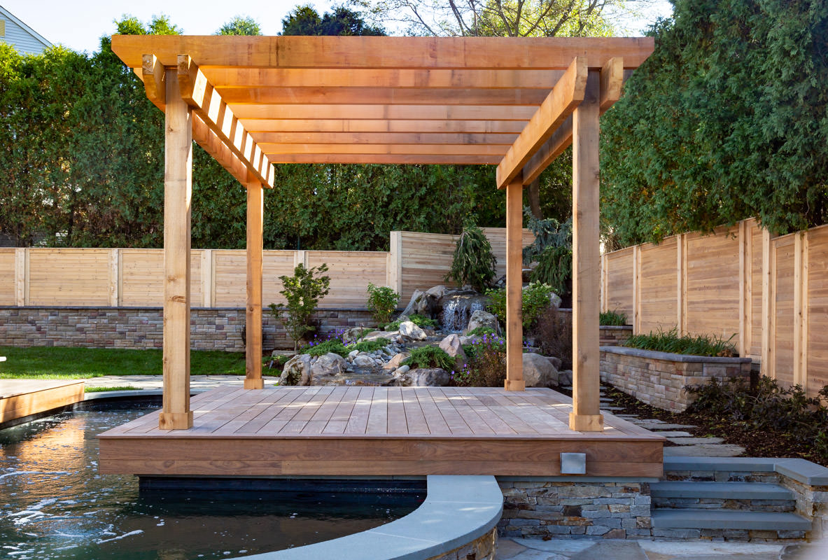 floating pergola over koi pond with waterfall in background
