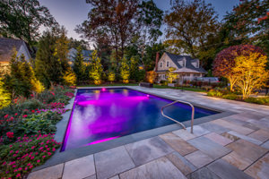 landscape lighting in backyard with swimming pool