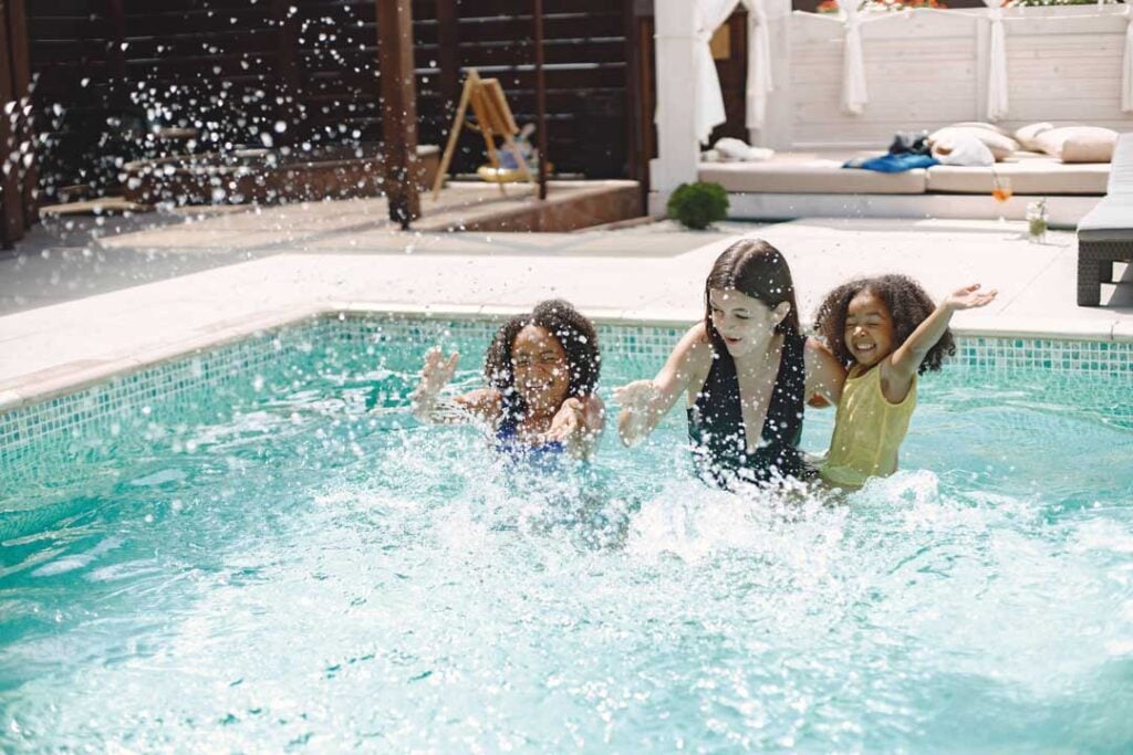 Playful pool fun—multiracial family enjoying swim time under the summer sun in Morris County.