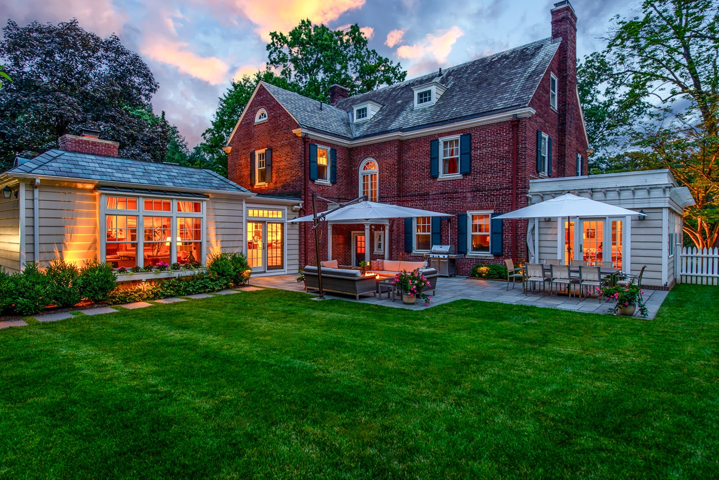Contemporary outdoor fireplace and garden patio lounge area in a professionally landscaped Maplewood, NJ backyard.