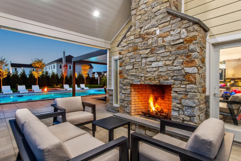 Outdoor fireplace beside pool by CLC Landscape Design, New Jersey swimming pool designer