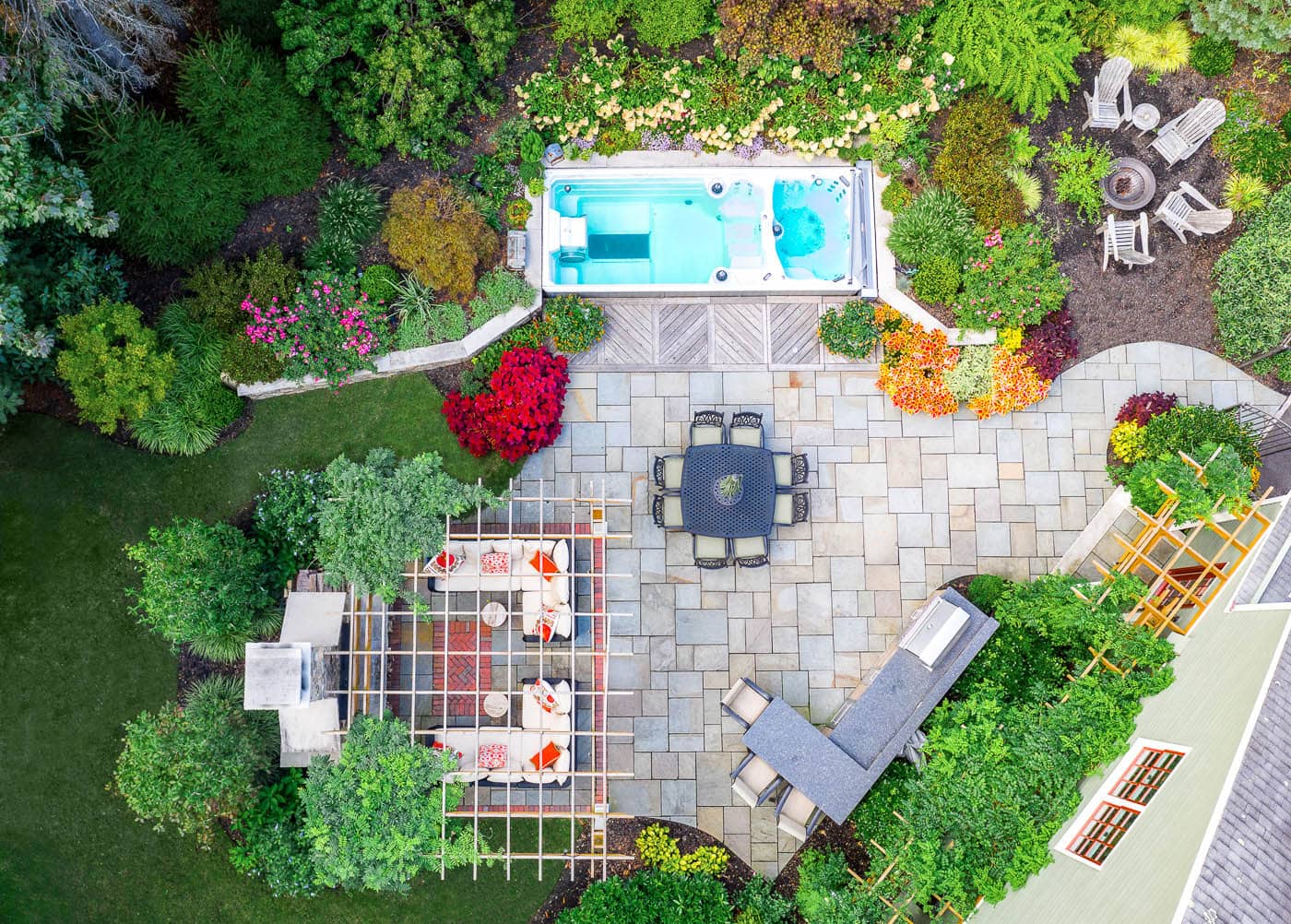 Mix of low-maintenance perennials and vibrant seasonal flowers softening hardscape edges in a Franklin Lakes residential landscape.