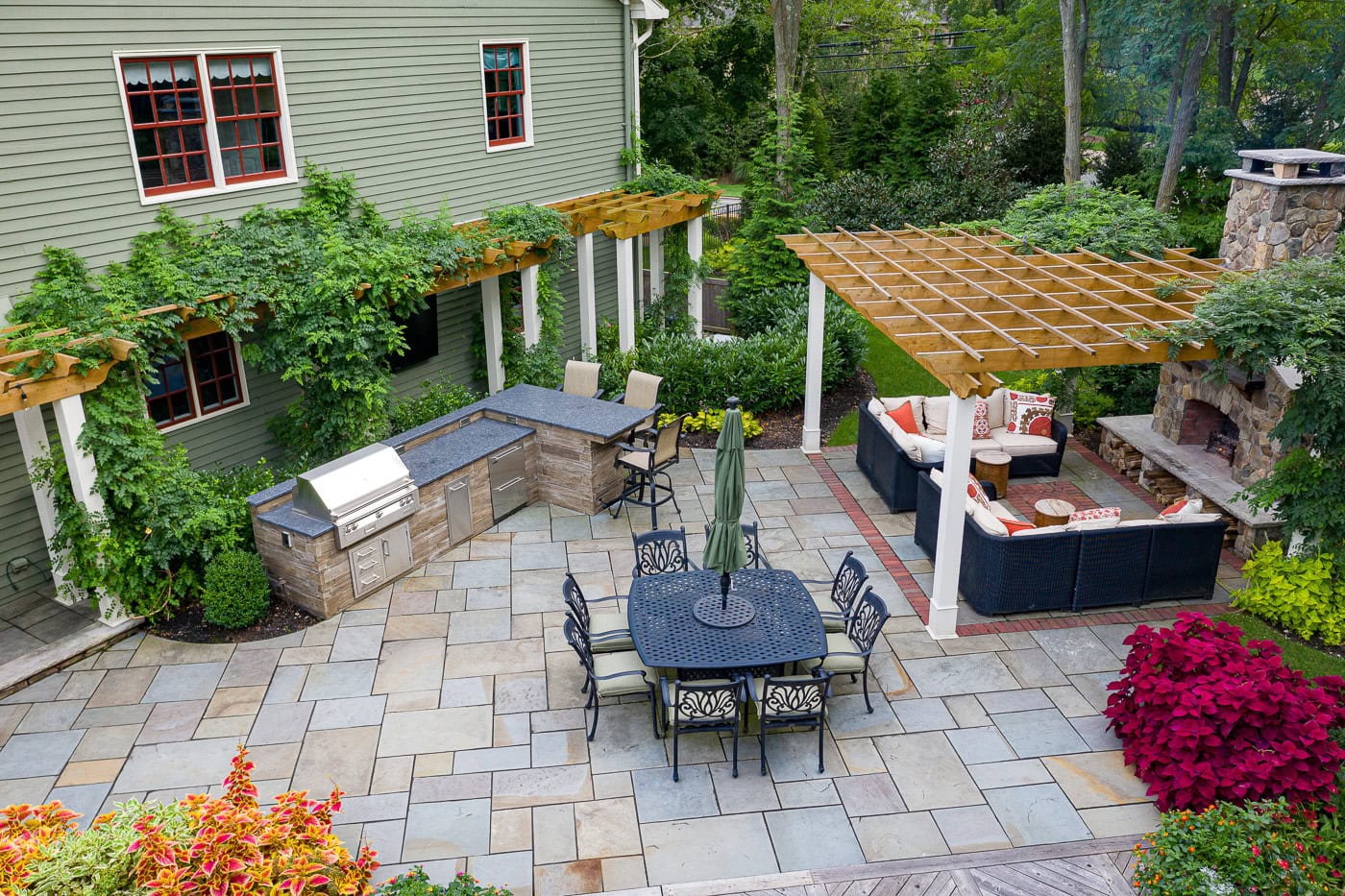 Overview of a serene backyard landscape in Franklin Lakes, NJ featuring layered garden beds, mature trees, and seasonal color by CLC Landscape Design.