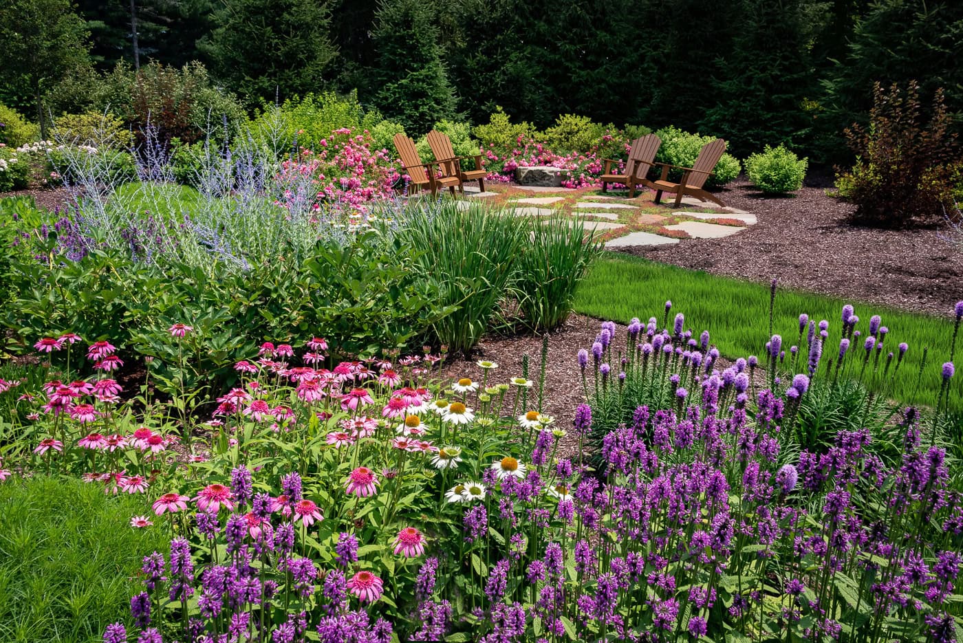 Completed backyard landscape in Kinnelon, NJ featuring lush plantings, defined garden beds, and a polished design by CLC Landscape Design.