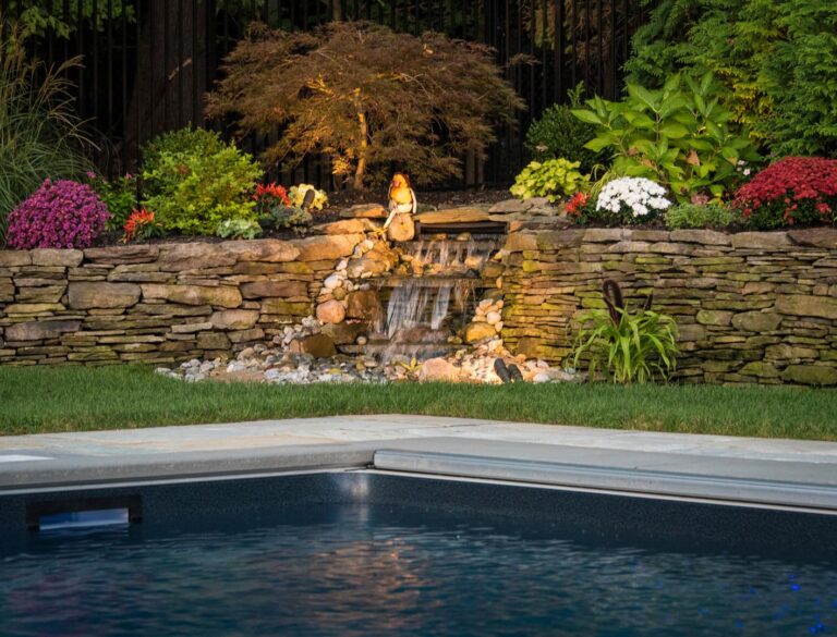 Family-friendly backyard with pool, lawn, and play area designed by CLC Landscape Design in Livingston NJ